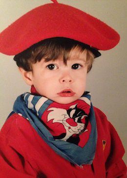 Un jeune Jean-François portant un pull rouge et un béret rouge